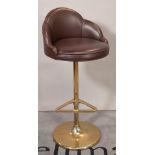 A 20th century brass and leather bar stool, on a circular plinth base, 46cm wide x 102cm high.