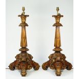 A pair of Continental walnut carved table lamps of rococo style, early 20th century,