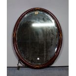 An Edwardian inlaid mahogany oval wall mirror with bevelled glass, 53cm wide x 68cm high.