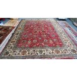 A Tabriz carpet, Persian, the madder field with an allover flower,