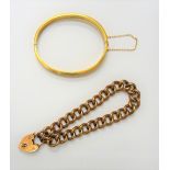A gold hollow curb link bracelet, detailed 9 C, on a gold heart shaped padlock clasp,