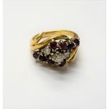 A gold, diamond and ruby ring, claw set with the principal circular cut diamond to the centre,