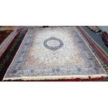 A Kashan part silk carpet, Persian, the ivory field with an indigo lobed medallion,