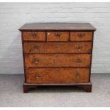 A George I feather banded burr walnut chest with three short over three long graduated drawers,