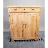 An early 20th century pine side cabinet with single drawer over panelled doors,