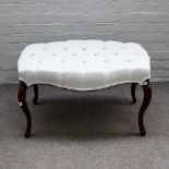 A mahogany framed footstool, with button upholstered serpentine shape top on cabriole supports,