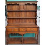 An 18th century style oak dresser, the enclosed two tier plate rack with spice cupboard,