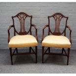 A pair of George III mahogany shield back open armchairs on tapering square supports,