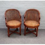 A pair of Louis XV style walnut and cane tub back armchairs on fluted supports and 'X' frame