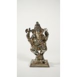 An Indian silver coloured metal figure of Ganesh, the elephant god standing on a square base, 17.