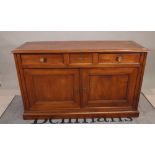 A 19th century French fruitwood side cabinet with three drawers over a pair of panel cupboards on