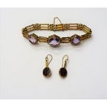 A gold and amethyst bracelet, in a three row bar and oval link design,