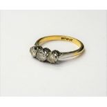 A gold and platinum, diamond set three stone ring, claw set with a row of circular cut diamonds,