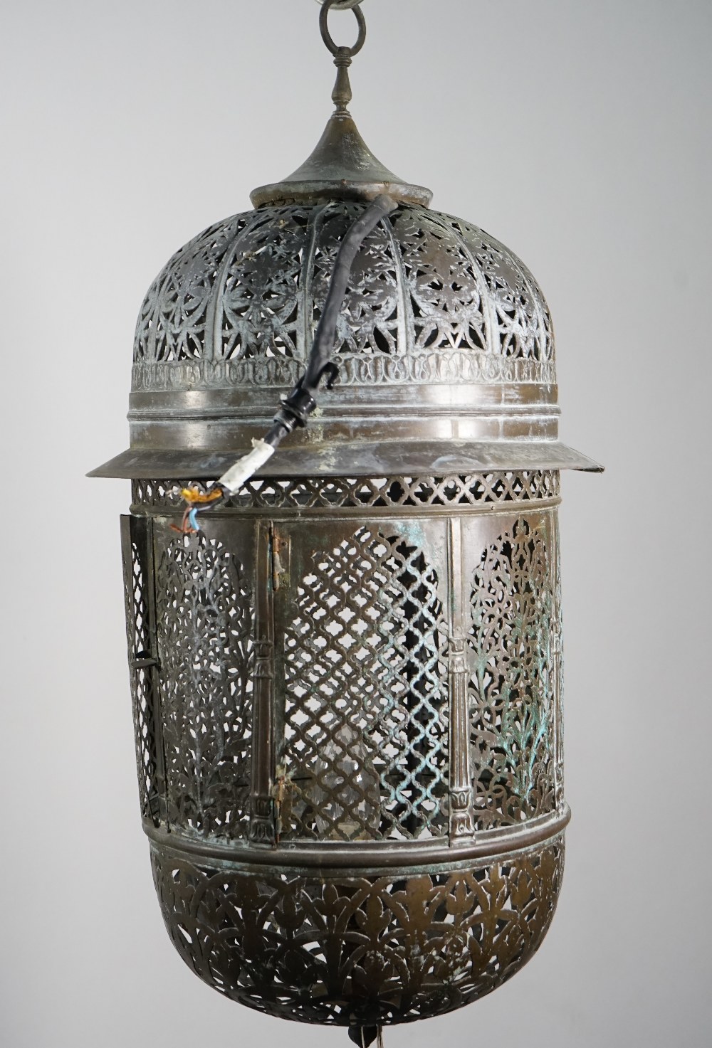 A pierced brass wall lantern, early 20th century, of Moroccan style with domed top and bottom,