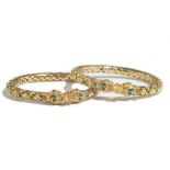 An Asian pair of gold and varicoloured gem set circular hinged bangles, each mounted with green,