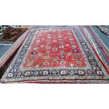 A Tabriz carpet, Persian, the madder field with an allover palmette, flower and vine design,