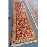 A Turkish runner, the madder field with a palmette, acanthus leaf and flower vine design,