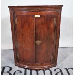 An 18th century oak hanging bowfront two door cabinet, 68cm wide x 91cm high.