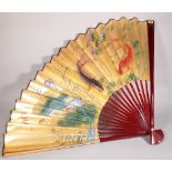 A large 20th century Japanese paper fan decorated with Koi carp, 75cm long x 118cm wide.