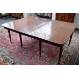 A Regency mahogany extending dining table, the rounded rectangular top on reeded supports,