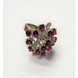 A ruby and diamond ring, in a pierced abstract design, mounted with mostly oval cut rubies,