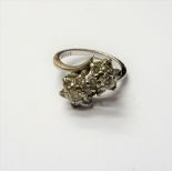 A white gold and diamond ring, in a twin cluster crossover design,