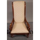 A 19th century mahogany framed scroll armchair on turned supports, 60cm wide x 105cm high.