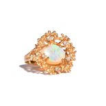 A gold, opal and diamond ring, claw set with the oval opal at the centre,