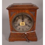 An early 20th century oak cased mantel clock with silvered dial and an eight day movement,