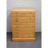 A 20th century light oak campaign style canteen chest with nine long graduated drawers on plinth