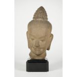 A Bayon style composition head of Buddha, 25cm. high, wood base.