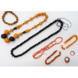 A coral bead necklace, two further bead necklaces, three reconstituted amber bracelets,