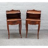 A pair of French oak serpentine fronted two tier single drawer bedside tables, on cabriole supports,