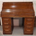 A late 19th century oak roll top pedestal desk, with eight drawers about the knee,