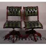A pair of 20th century office chairs with green button back leather upholstery,