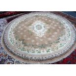 An Indian circular rug, the fawn field with floral ivory centre, floral border, 280cm diameter.
