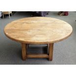 An 18th century style oak circular dining table on block supports and stretchers,