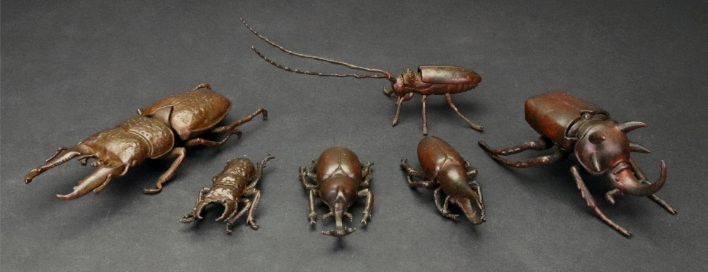 A group of six small Japanese bronze or copper models of varying types of beetle, 20th century,