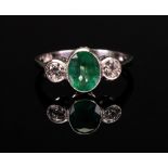 A three-stone emerald and diamond ring, the oval-cut emerald, approx. 1.