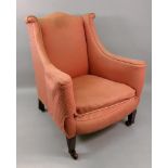 An Edwardian upholstered arched wing back armchair, in George III style,