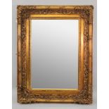 A large reproduction ornate gilt frame wall mirror, in 18th century style, with bevel edge plate,