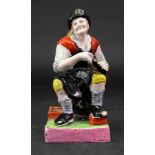 A pearlware figure of a seated cobbler, circa 1800, 16cm high. **From the Brook-Hart collection.