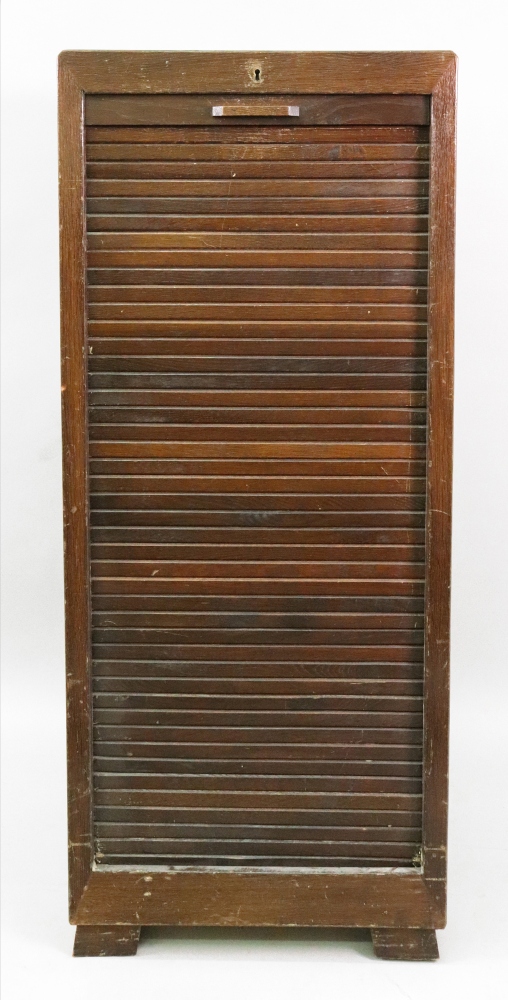 An oak filing cabinet,mid 20th century, the tambor shutter enclosing sliding trays,