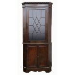 A George III mahogany floor standing corner cabinet,