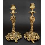 A pair of rococo style gilt metal candlesticks, 19th century, cast with fruiting vines,