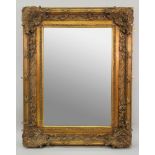 A large reproduction ornate gilt frame wall mirror, in 18th century style, with bevel edge plate,