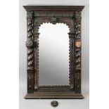 A late Victorian carved oak frame upright wall mirror, with half round barley twist columns,
