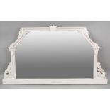 A Victorian later white painted overmantel mirror of shaped outline, lotus and leafy scroll carved,