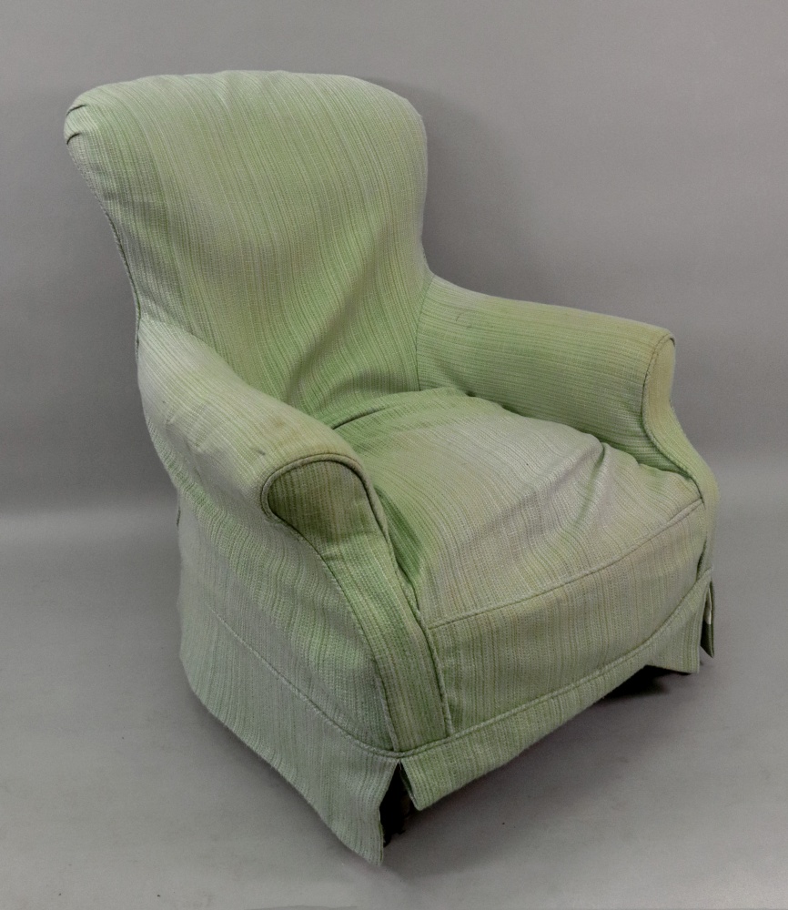 A Victorian button down upholstered armchair, on turned legs, with green loose cover.