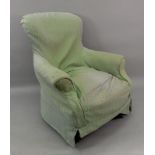 A Victorian button down upholstered armchair, on turned legs, with green loose cover.